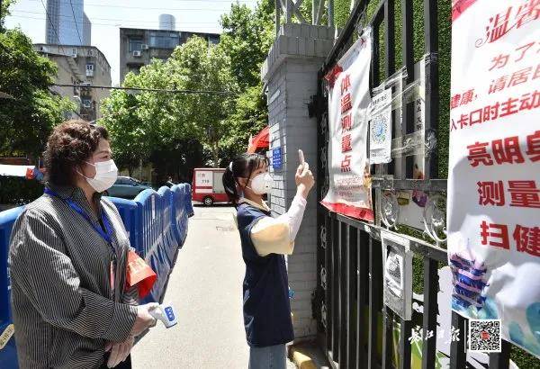 5月12日中午，江汉区北湖街工委副书记毛芸在小区出入口叮嘱居民测量体温。长江日报记者郭良朔摄