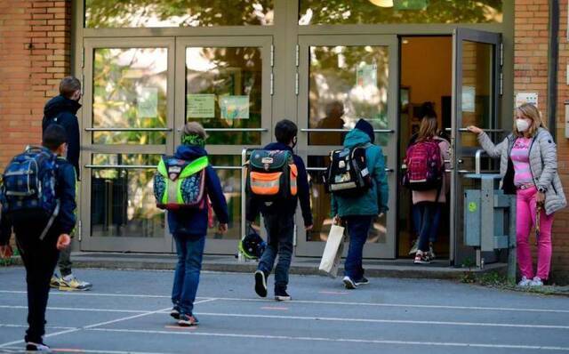  5月7日，在德国多特蒙德，学生们保持社交距离进入学校。新华社/法新