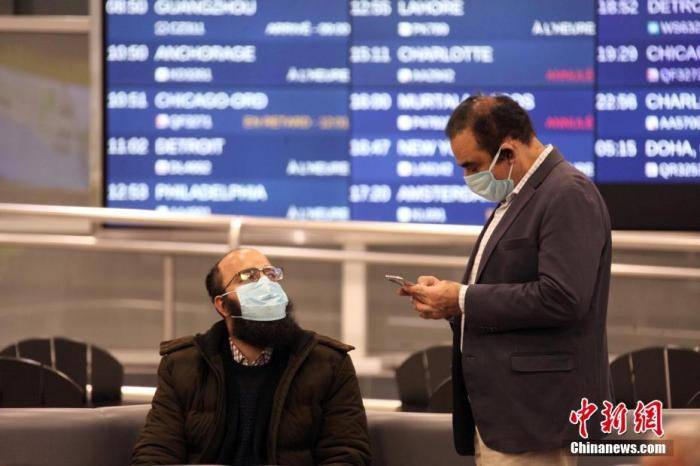 疫情期间，两位戴口罩的旅客在冷清的加拿大多伦多皮尔逊国际机场休息。中新社记者余瑞冬摄
