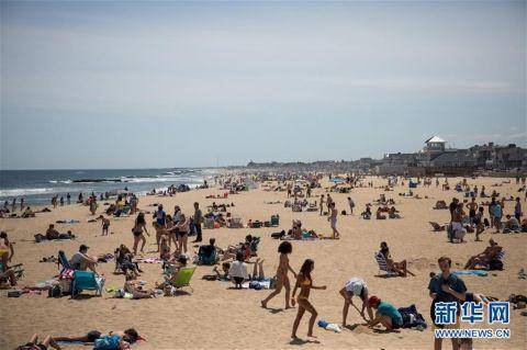 5月16日，人们在美国新泽西州贝尔马海滩享受阳光图片来源：新华社