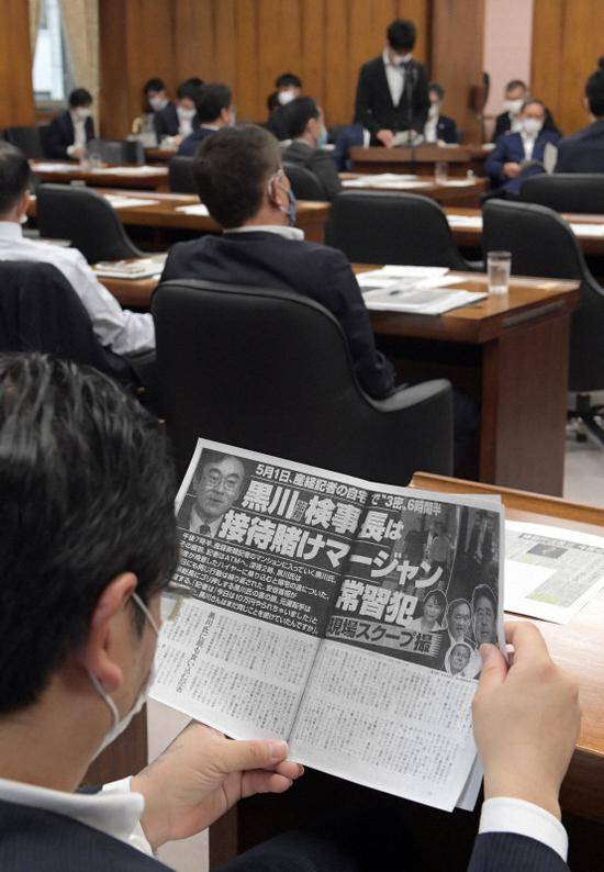 日本国会议员在看20日刊登的相关报道（每日新闻）