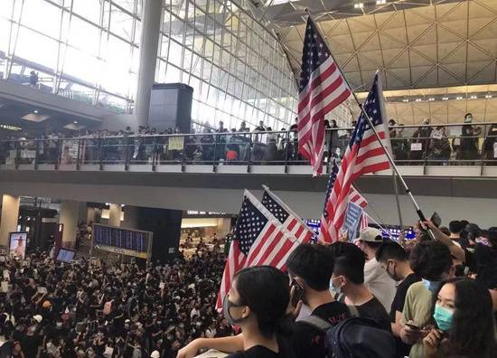 修例风波中，非法示威者阻塞香港机场，并打出美国国旗。（图：中新网）