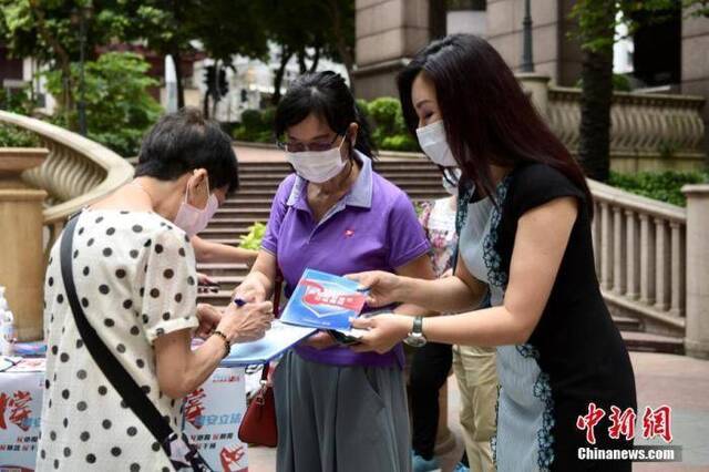 5月24日上午，市民纷纷来到街站签名支持。“香港各界撑国安立法联合阵线”于香港各区多个街站进行签名行动，位于上环新纪元广场的街站，有市民前来签名支持。中新社记者李志华摄