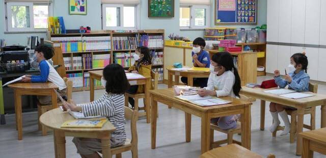 5月6日，韩国庆尚南道一所小学，学生在托管教室戴口罩上课。（韩联社）