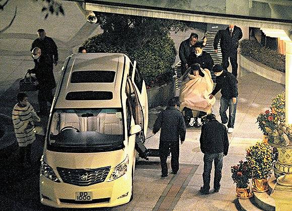 2011年2月5日晚上，何鸿燊离开四姨太家，由看护和保镖护送上车。