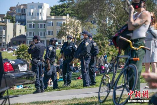 当地时间5月24日，美国旧金山警员在多洛雷斯公园执勤。很多美国人选择在户外庆祝将士阵亡纪念日长周末，公共卫生官员担忧，大型聚会可能导致疫情再次暴发。中新社记者刘关关摄