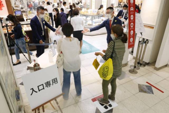 5月25日，日本全国解除紧急事态宣言后，民众正在排队进入东京银座某百货商场。/共同社网站截图