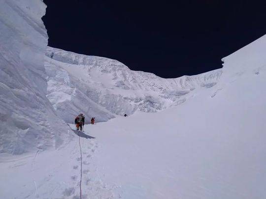 资料图：2020珠峰测量登山队的修路队员固定铺设在北坳冰壁上的路绳。巴桑塔曲摄图片来源：中国登山协会