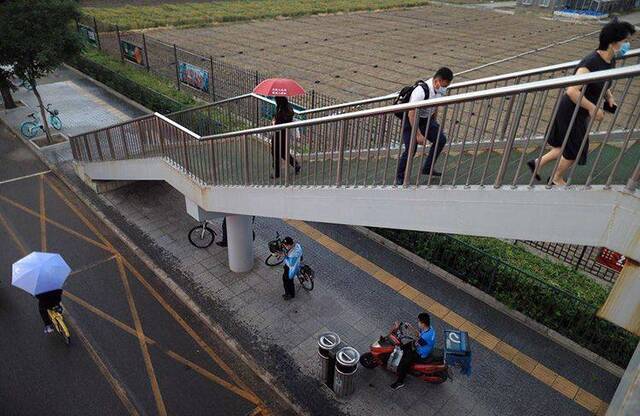 中关村东路，市民在过街天桥下躲雨。