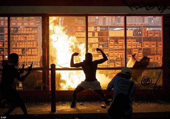 抗议者在一家商店内纵火（图源：美联社）