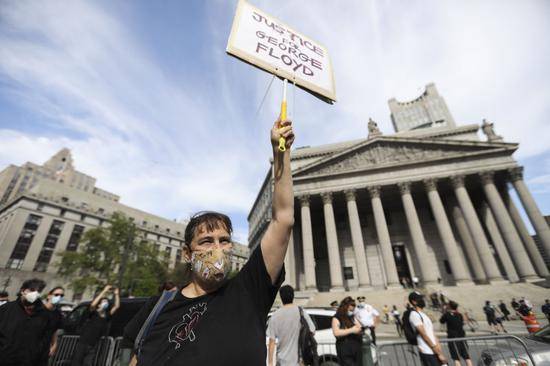 ↑5月29日，在美国纽约，一名抗议者打出抗议标语。