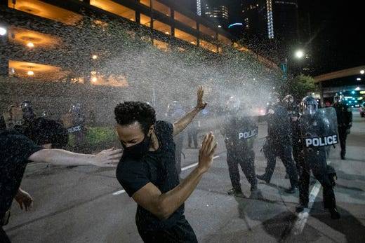 身穿防暴装备的底特律警察向抗议者喷洒胡椒喷雾图源：底特律自由新闻报
