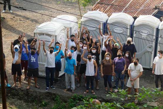 5月17日，在萨尔瓦多首都圣萨尔瓦多，卡洛斯（化名）和其他被遣返移民在一处集中隔离点向记者招手。新华社发（亚历山大·培尼亚摄）