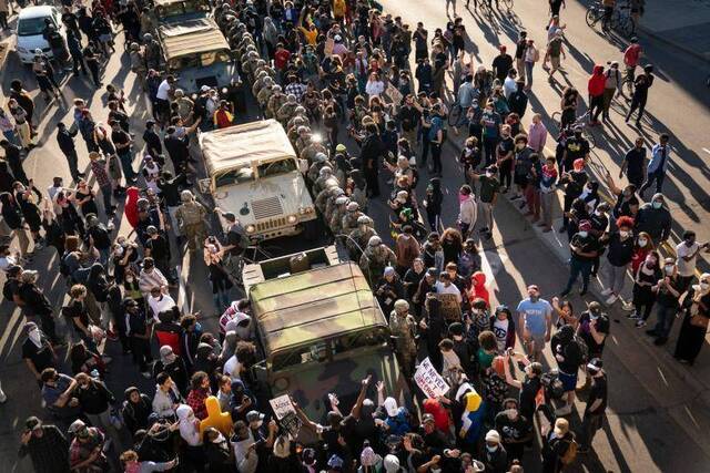 △明尼阿波利斯市中心，国民警卫队被示威者包围图片来源：《纽约时报》