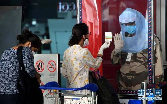 ▲5月25日，在印度新德里英迪拉·甘地国际机场，安保人员核对旅客身份信息。新华社发（帕塔·萨卡尔摄）