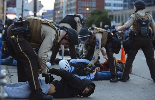 5月31日，在美国明尼苏达州明尼阿波利斯市，示威者被警察逮捕。新华社图