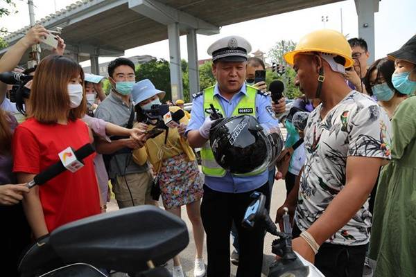 石家庄交警送头盔，宣传“一盔一带”。受访者供图