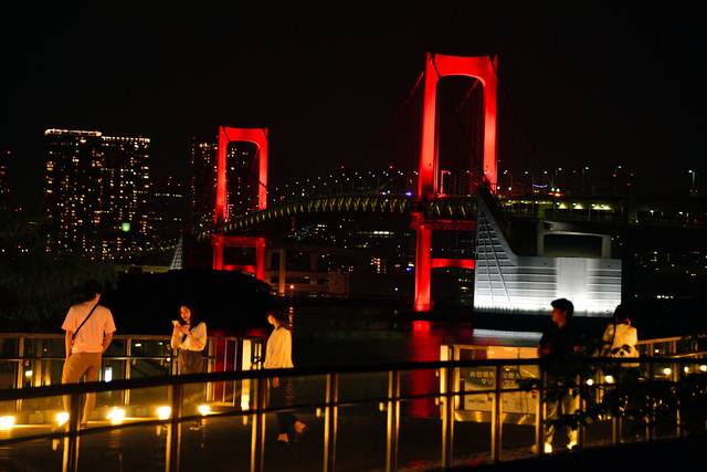 “东京警报”拉响后，东京湾彩虹大桥点亮红色灯光（朝日新闻）