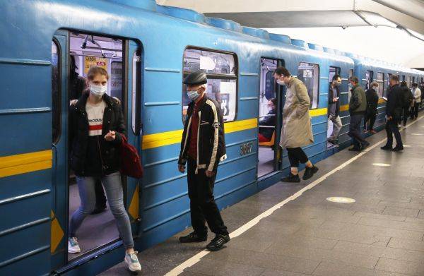 5月25日，乘客在乌克兰基辅市一地铁站内佩戴口罩上下车。新华社发