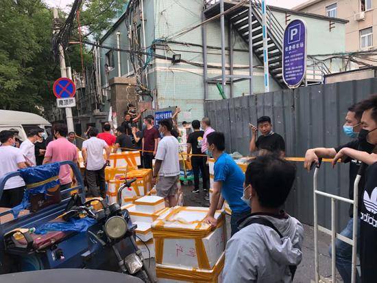 6月13日下午，北京大红门京深海鲜批发市场北门，市场的一些商户聚集在此，将产品从市场往外运走。摄影/本刊记者张旭