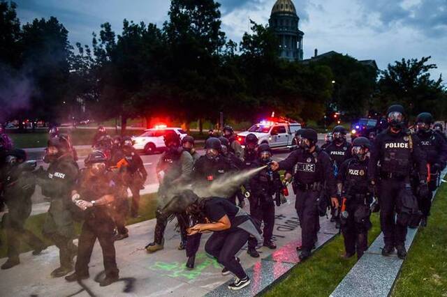 2020年5月30日，群众在科罗拉多州的丹佛连续第三夜抗议乔治.弗洛伊德之死，警员朝科罗拉多议会大厦旁的一名女性喷洒胡椒喷雾。 PHOTOGRAPH BY M