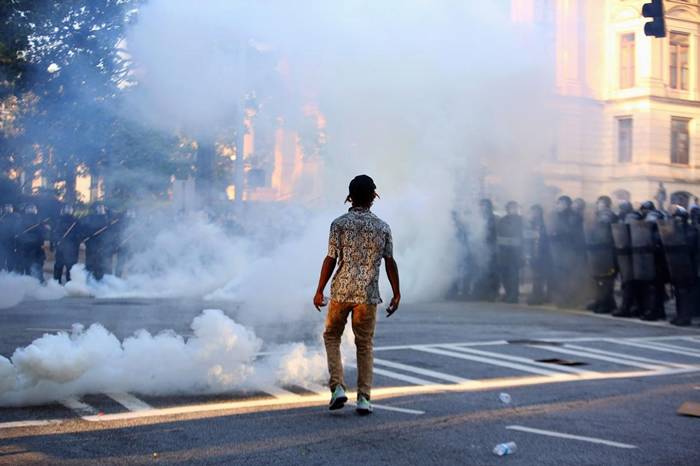 2020年6月1日，亚特兰大一场抗议乔治‧弗洛伊德之死的示威行动中，一位示威者就站在催泪瓦斯之中。乔治.弗洛伊德是死于明尼亚波利斯警方拘留期间的