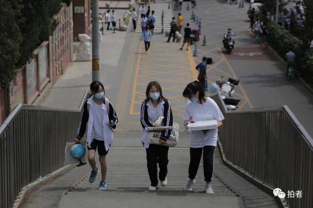 △6月17日，清华附中门口，三名学生带着个人物品离开。摄影/新京报记者郑新洽