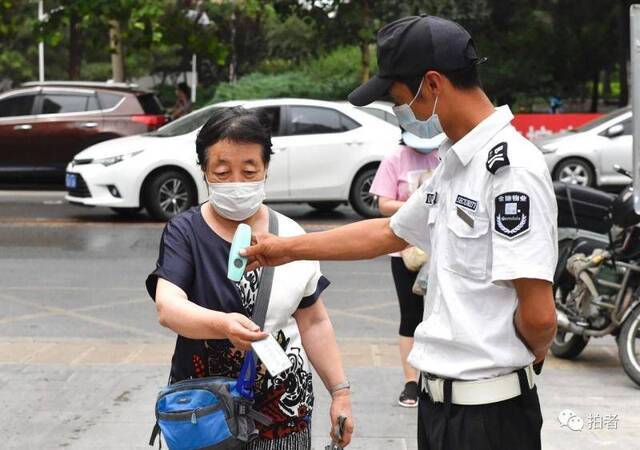 △6月17日，朝阳区一小区，居民进入小区需检测体温。摄影/新京报记者吴宁