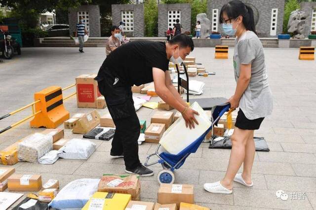 △6月17日，朝阳区一小区已禁止快递员上门送件，快递员需联系居民到小区入口处领取包裹。摄影/新京报记者吴宁