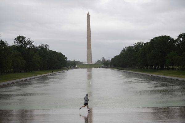 图说：5月6日，在美国首都华盛顿，一名男子在华盛顿纪念碑附近跑步健身。新华社记者刘杰摄