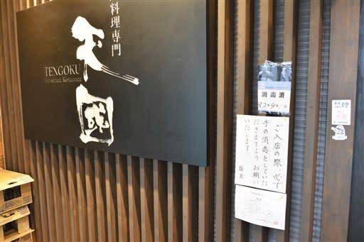 店门口贴着提醒顾客注意洗手的信息（熊本日日新闻）