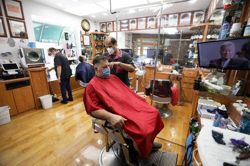 6月22日，顾客在美国纽约一家理发店理发。新华社记者王迎摄