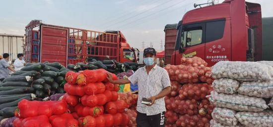 在新发地批发市场临时交易区，经营户正在盘点货品。受访者供图