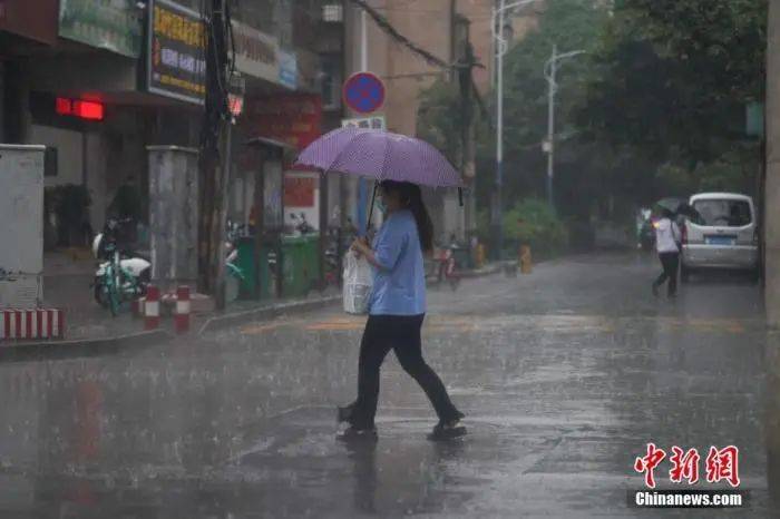 6月18日下午，云南省昆明市突降暴雨，市民冒雨出行。中新社记者刘冉阳摄