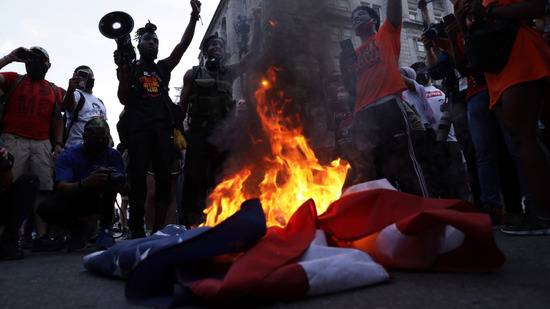 抗议者围绕着燃烧着的美国国旗图源：NBC
