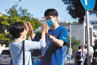 北师大附中考点，家长与考生击掌。新京报记者李凯祥摄