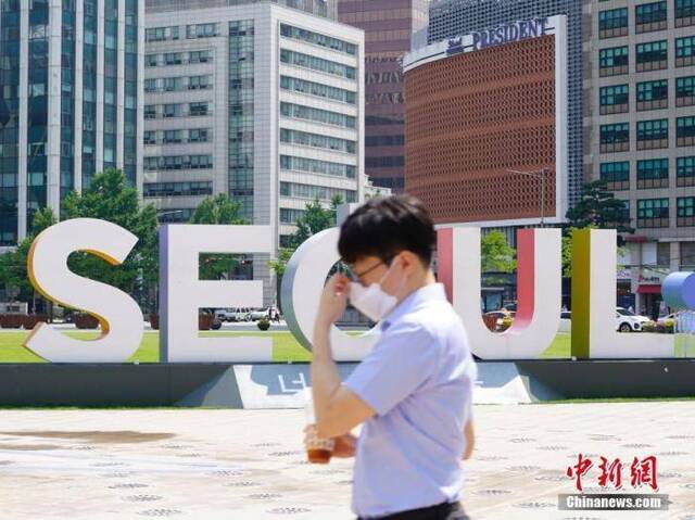  6月23日，一位韩国首尔市民经过首尔广场。近来，包括韩国首尔、仁川、京畿道在内的首都圈确诊病例持续增加。中新社记者曾鼐摄