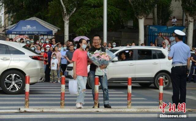  7月8日，内蒙古呼和浩特市一高考考点，考生结束考试后收到来自家长的鲜花。中新社记者刘文华摄