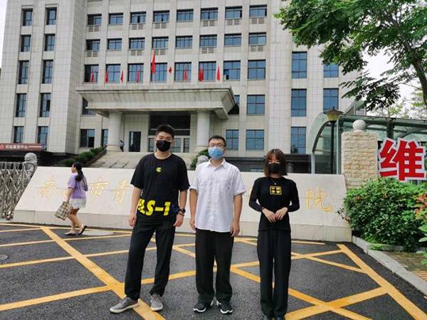  7月3日庭审之前，三名原“豫章书院”学员在法院门口合影。澎湃新闻记者朱远祥图