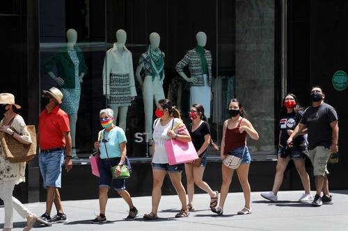 7月4日，人们戴着口罩走在美国纽约第五大道。新华社记者王迎摄