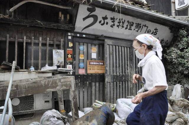 上村在收拾店面（共同社）