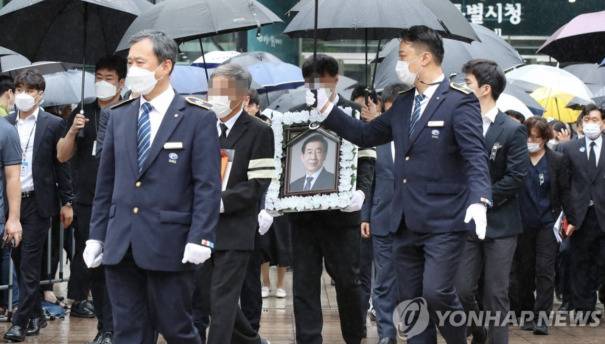 7月13日上午，在首尔市政厅，朴元淳的遗属捧着遗像到达遗体告别仪式现场。图片来源：韩联社