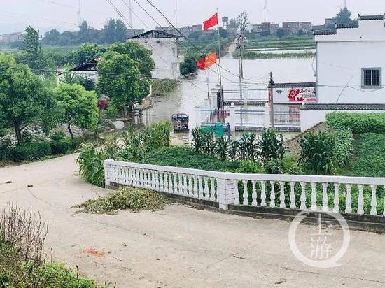  7月13日，江西九江市江洲镇，低洼地带的水泥路已被江水淹没。/记者时婷婷