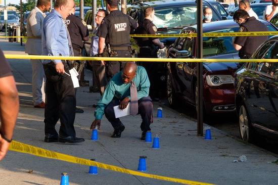 当地时间7月13日，警察在布鲁克林罗克威公园大道的枪击案现场检查弹壳。（图源：纽约日报）