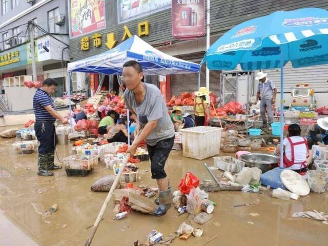 天放晴后，有人在帮忙从污水中分拣货物。图/受访者供图