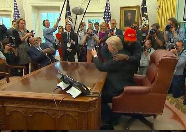 “侃爷”头戴“小红帽”与特朗普拥抱，视频截图