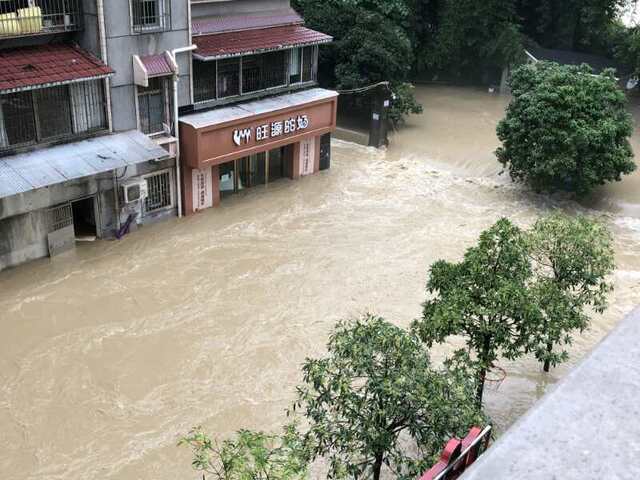 7月17日下午，清江河水漫过亲水走廊倒灌入城区，形成瀑帘，一楼商铺被淹。受访者供图