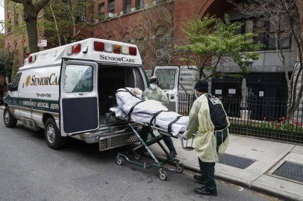▲资料图片：在纽约科布尔山健康中心门口，一名老年患者被抬上救护车（美联社）