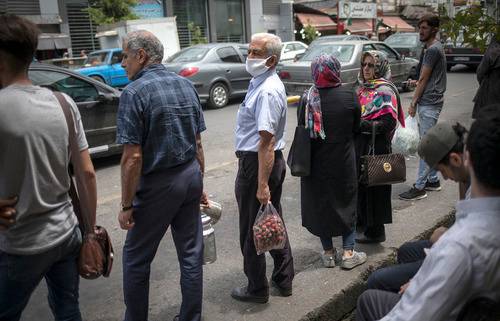  6月5日，人们在伊朗通卡邦的街道旁等待出租车。新华社发（艾哈迈德·哈拉比萨斯摄）
