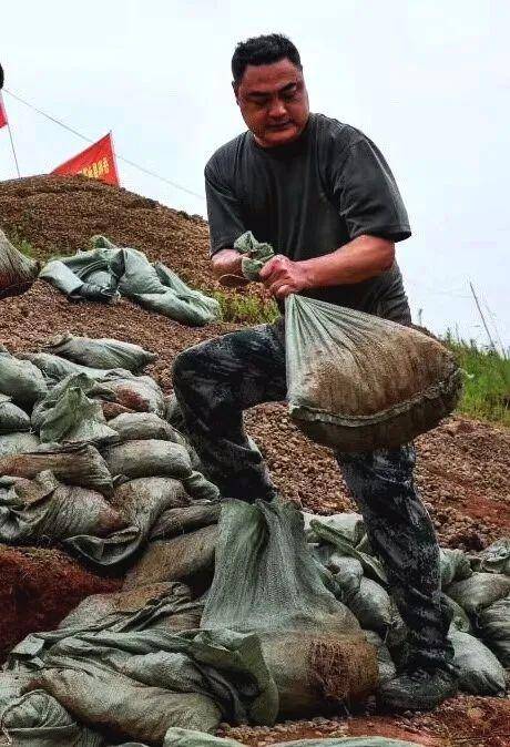 受持续强降雨影响，湖南岳阳县出现险情，退役军人火速抢险，安全护堤。图/文龙春涛周金良